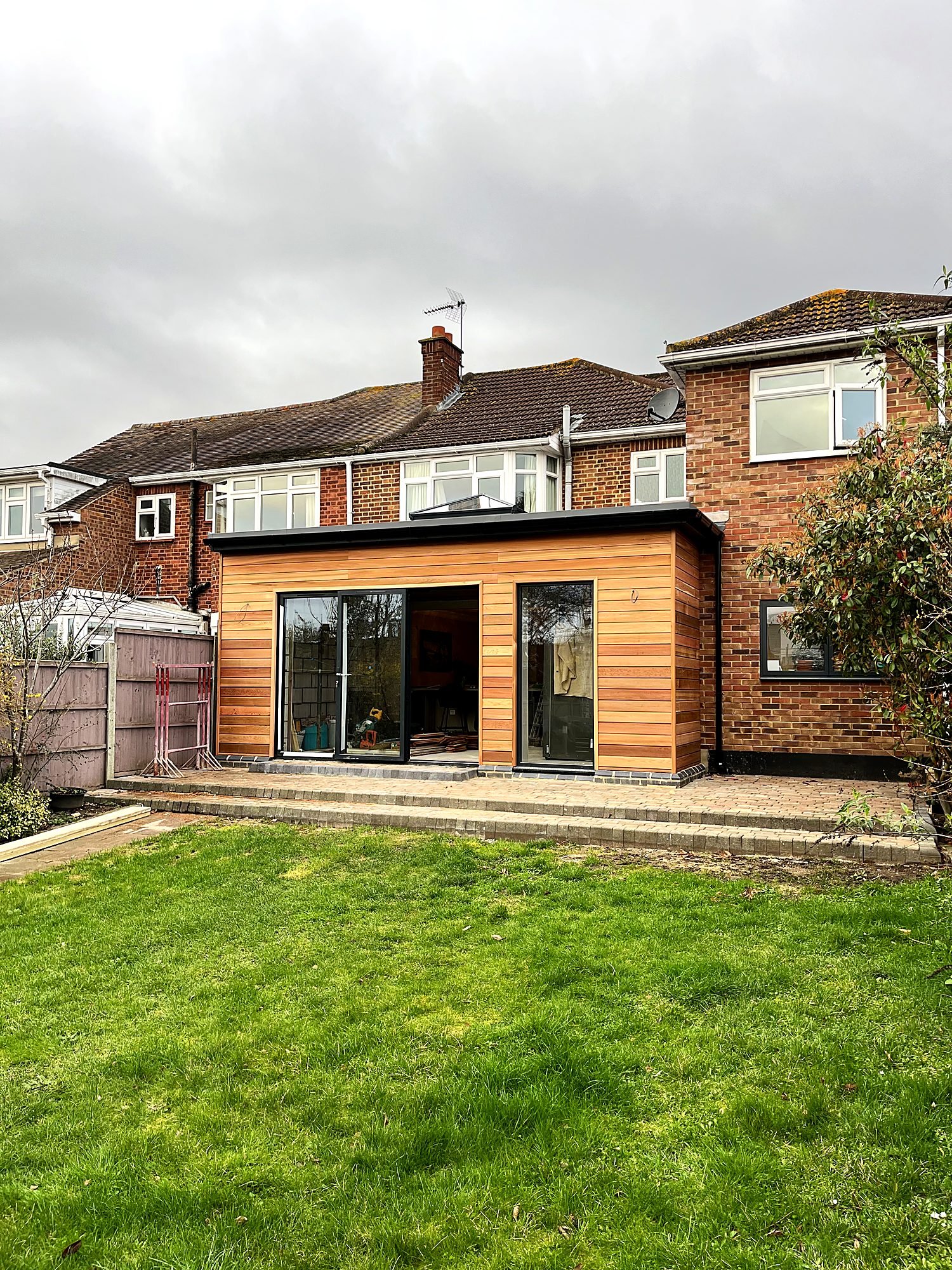 Rear house extension clad in western red cedar with bifold doors and a roof lantern